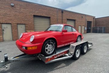 Ein roter Porsche 911 auf einem U-Haul Autotransportanhänger.