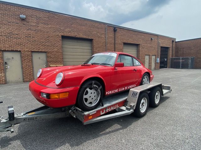 Ein roter Porsche 911 auf einem U-Haul Autotransportanhänger.