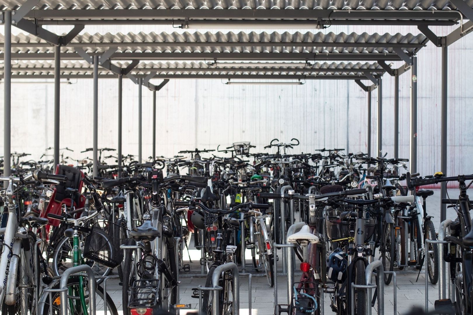Dicht belegter Fahrradparkplatz unter einem überdachten Stahlgestell
